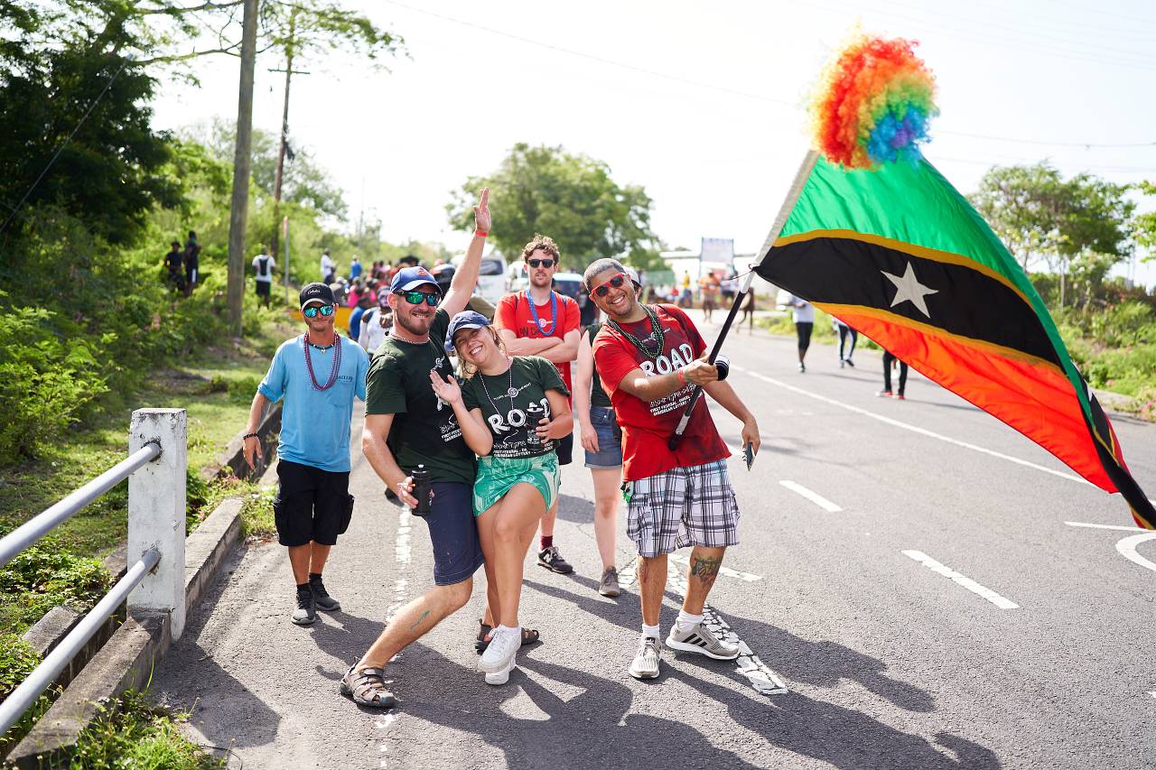 Revellers on the road during Culturama in Nevis, one holding the St. Kitts and Nevis flag
