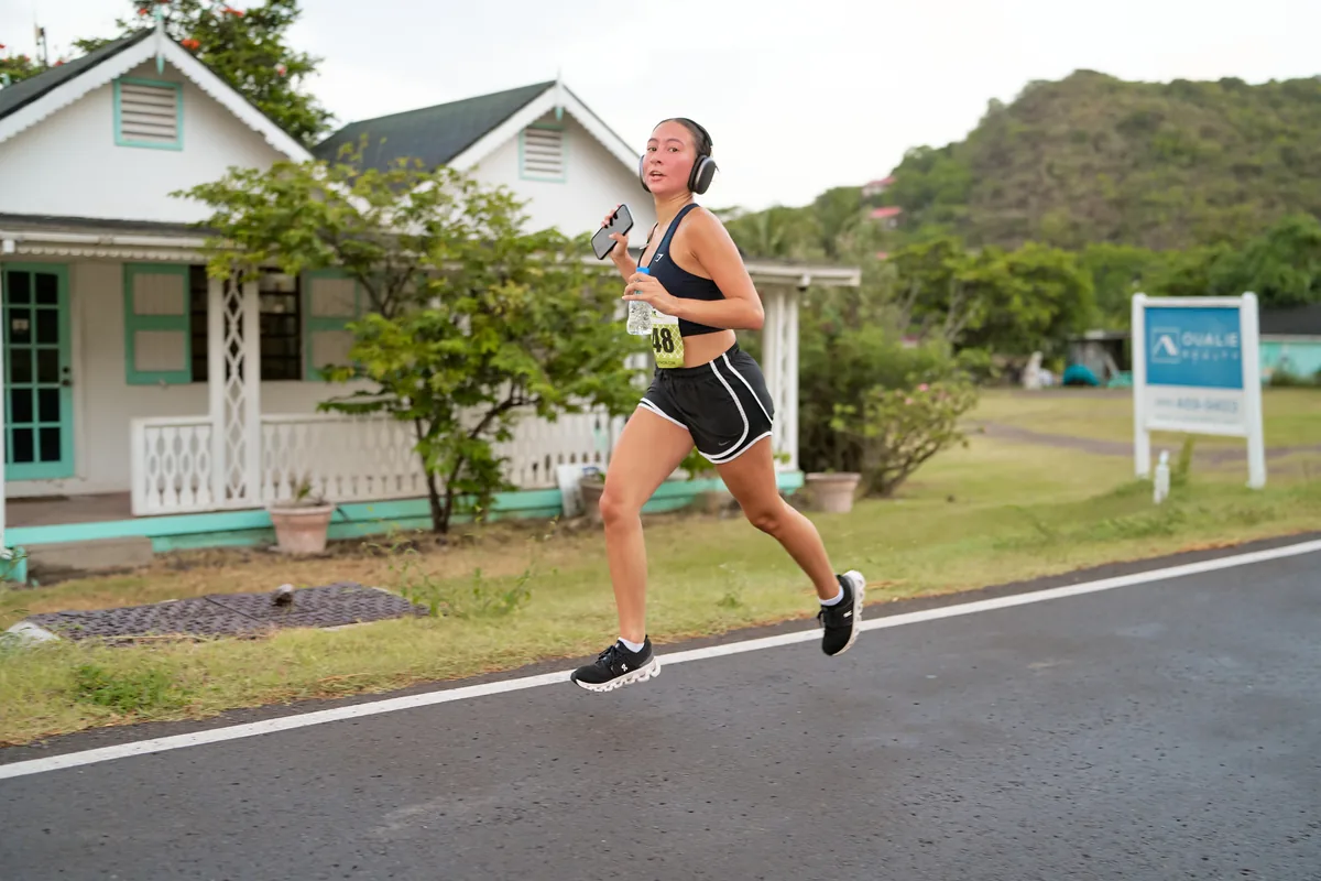 A runner passing a traditional Nevisian house on the road near Oualie Beach
