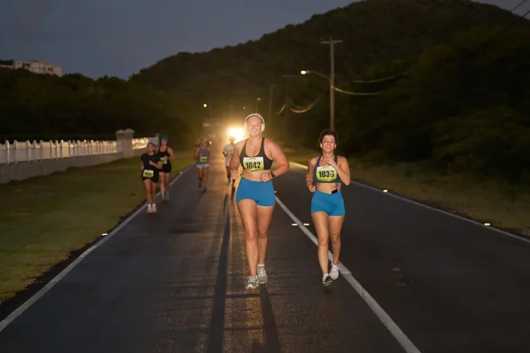 Two runners on a coastal road in Nevis at first light during the Nevis Marathon