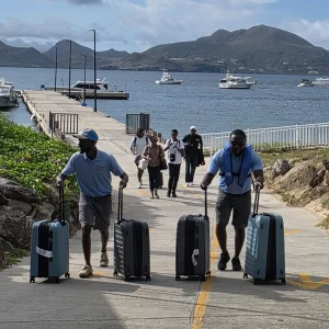 Crew handling guests' luggage after arrival at Oualie Pier, Nevis