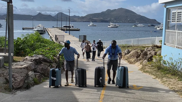 Crew handling guests' luggage after arrival at Oualie Pier, Nevis